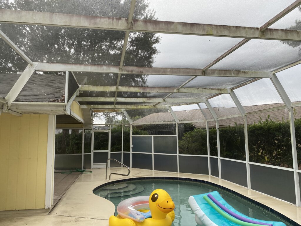 Dirty white pool cage with mold and grime buildup, showcasing the need for professional pressure washing services.