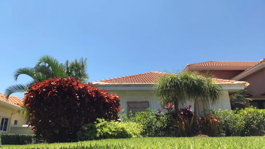 Wide front view of the Prestancia home during exterior coating with masking still in place