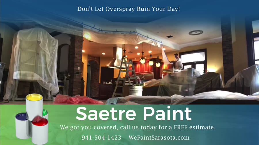 Kitchen cabinets and nearby surfaces covered with plastic before interior painting