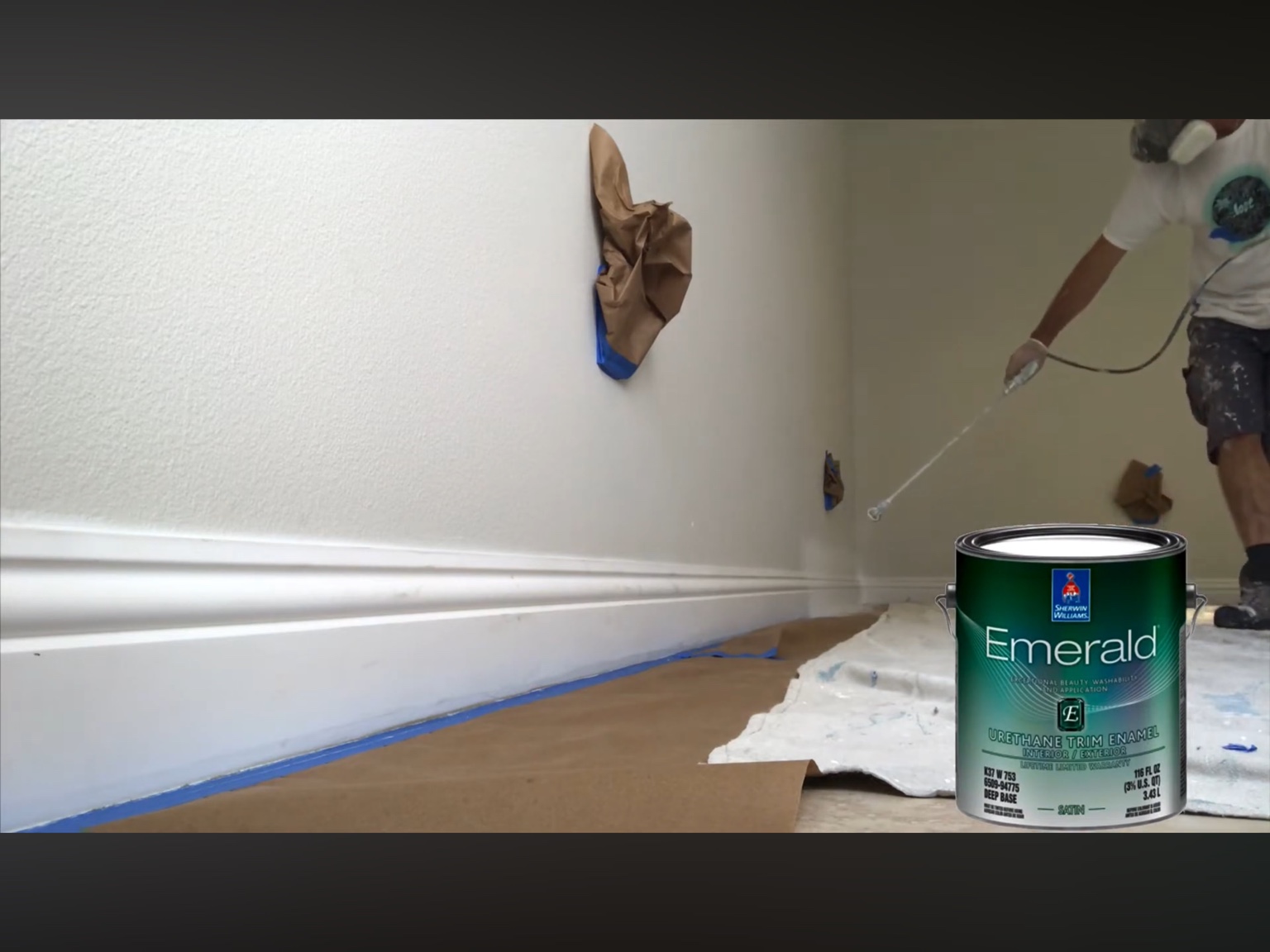 Painter spraying white baseboards in a Sarasota home