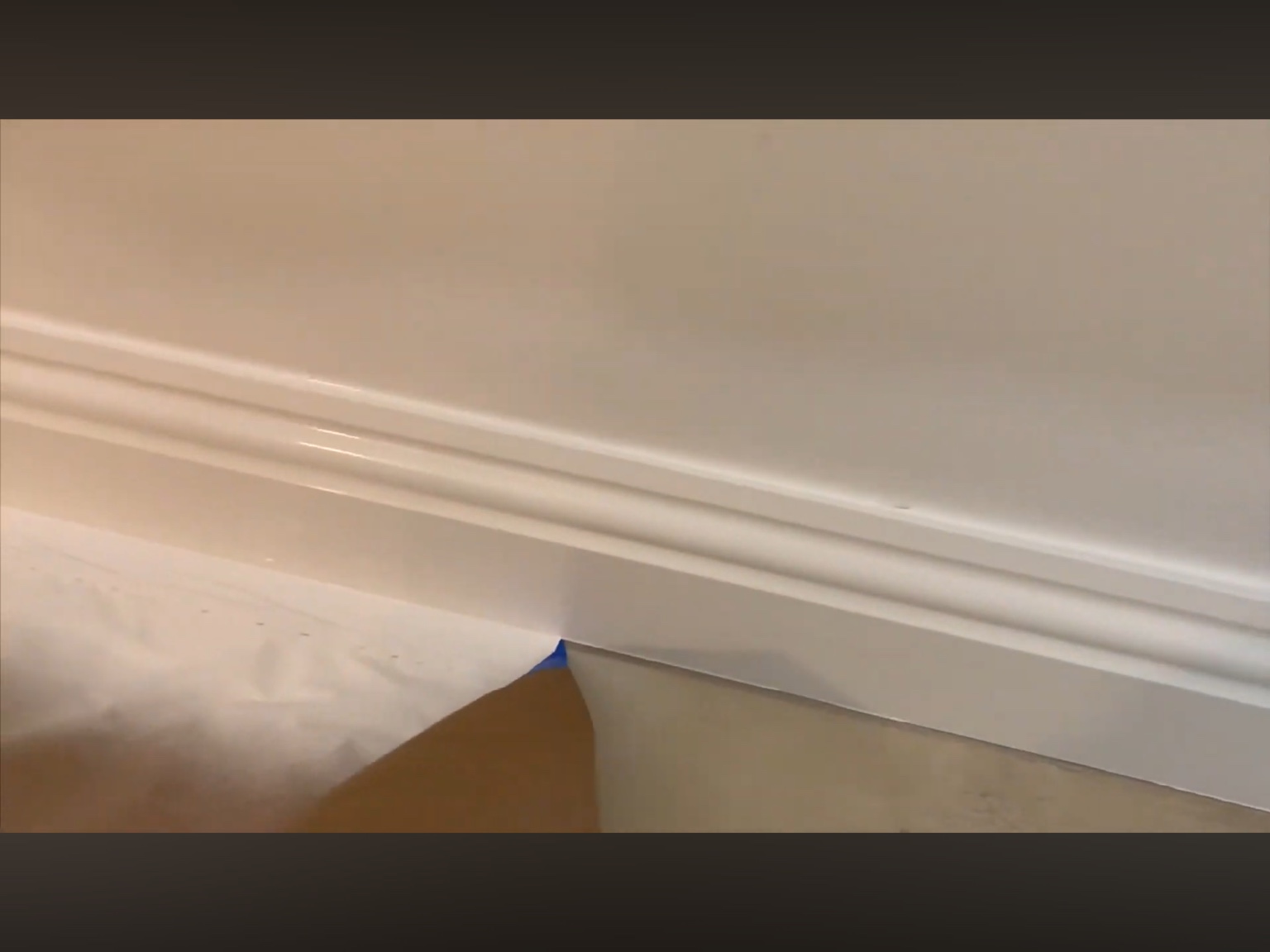 White painted baseboards with protective masking still in place